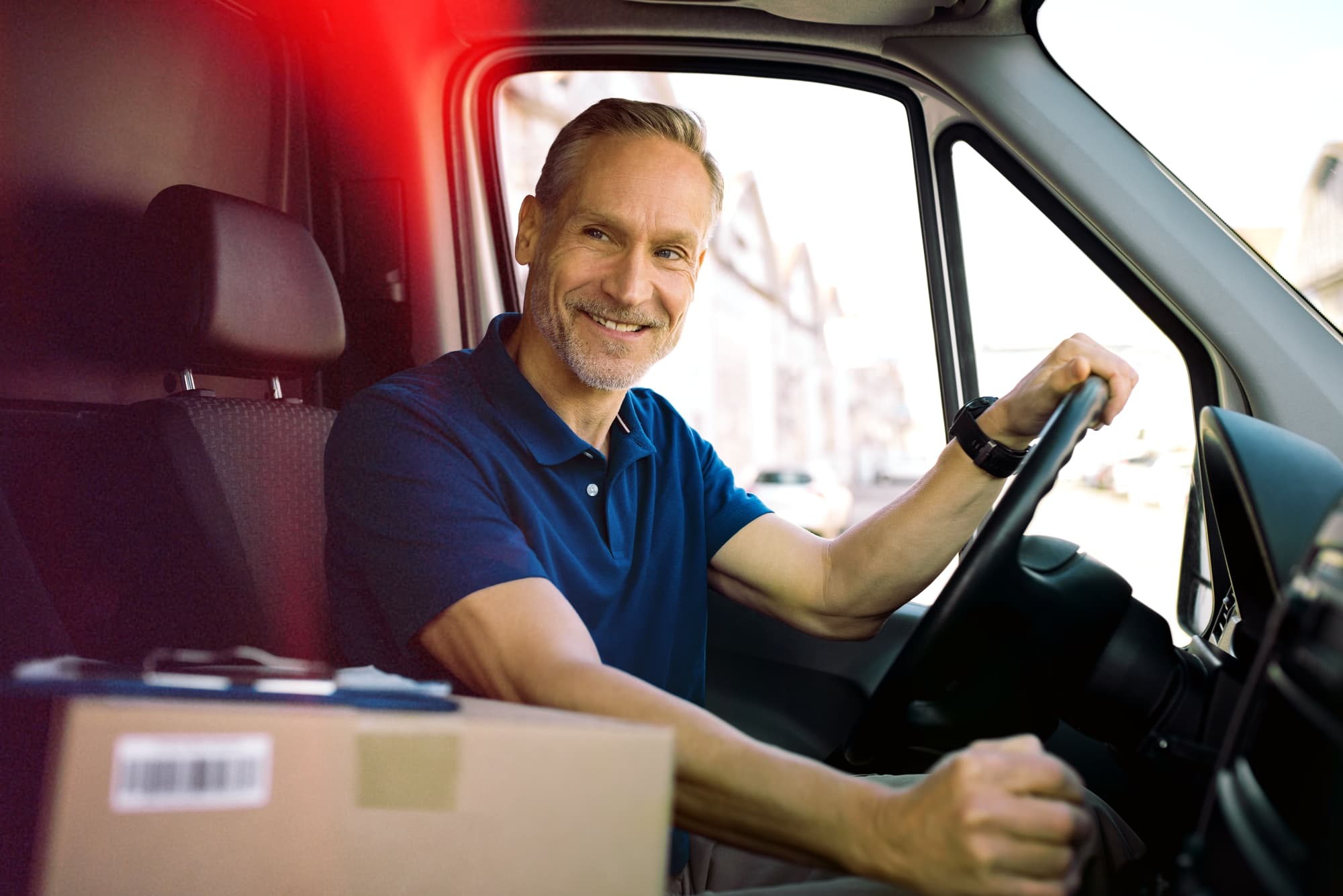 GPS van tracking solutions for logistics and courier fleet optimization Logistics delivery driver with package and tracked van using the best van tracker UK logistics companies trust