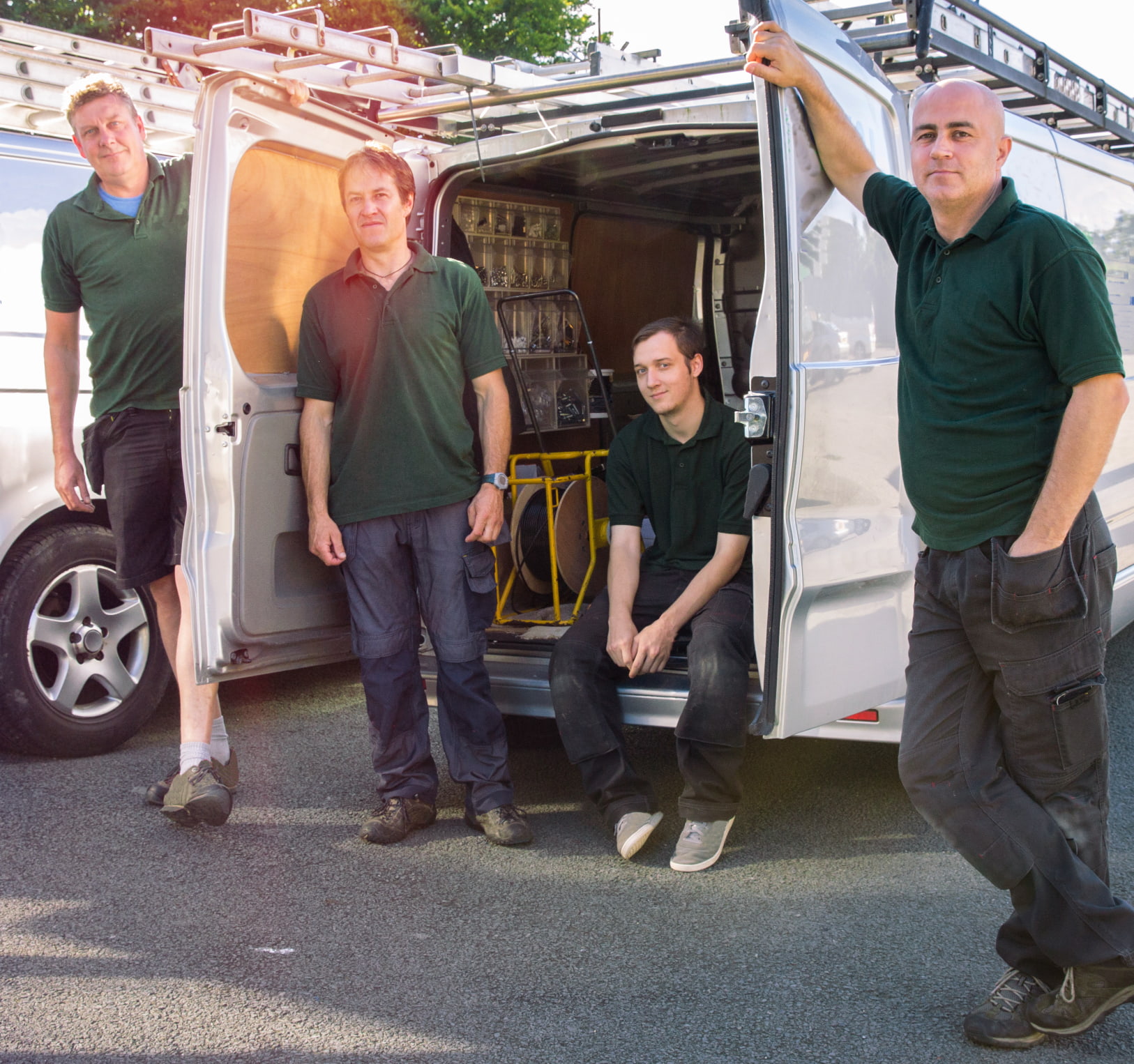 Construction worker with safety equipment accessing van with tracker for monitoring equipment