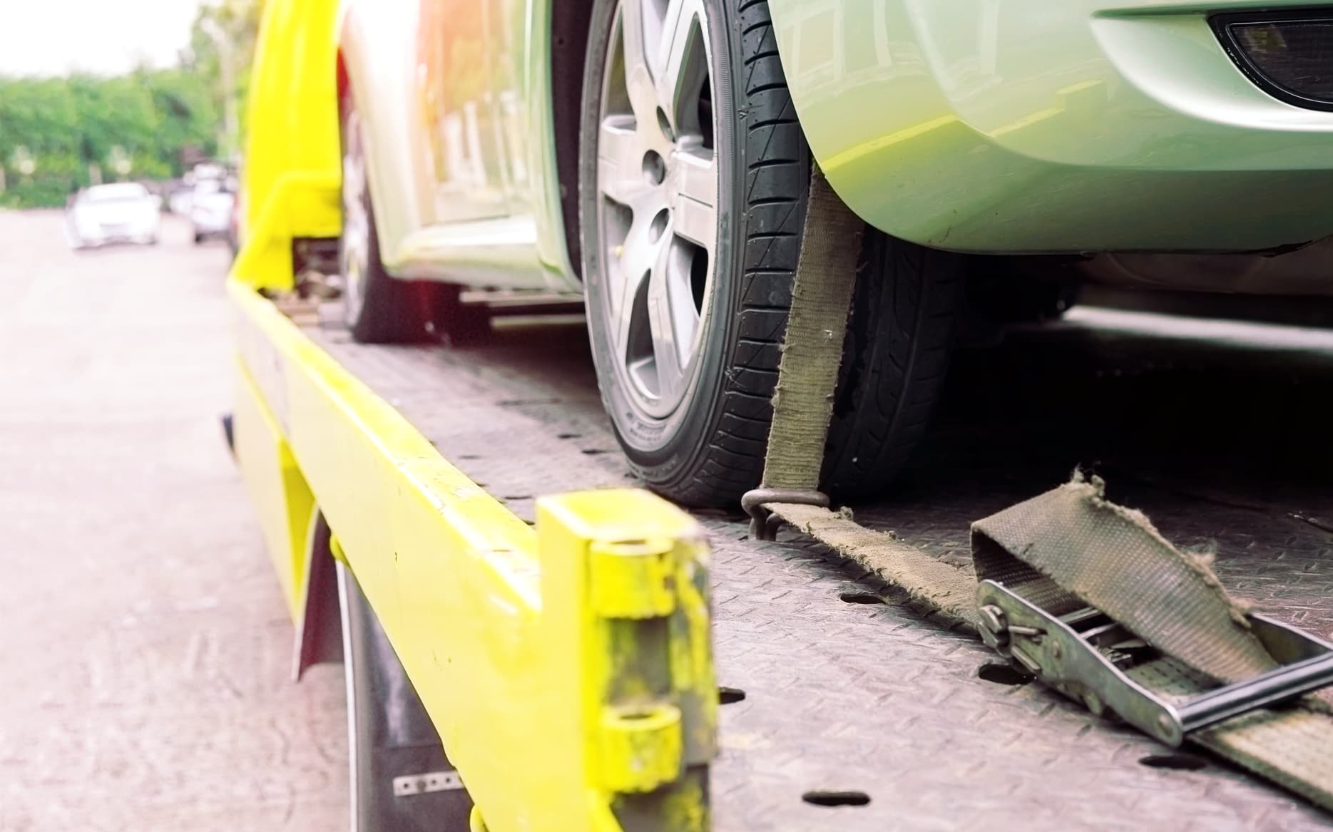 Recovery specialist using flashlight to locate hidden tracking device on stolen vehicle